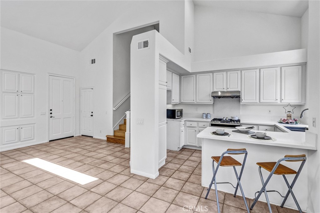 35 Del Cambrea Irvine, CA 92606 - Photo 8 of 31 a kitchen with stainless steel appliances granite countertop a stove a refrigerator and white cabinets