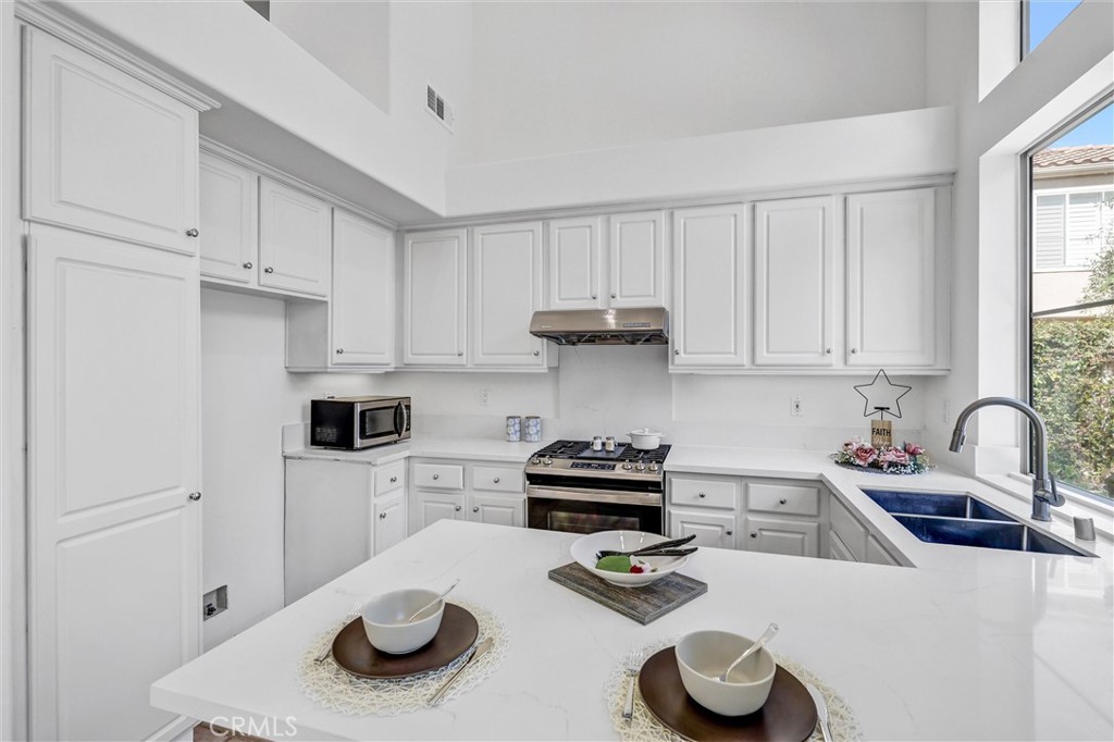 35 Del Cambrea Irvine, CA 92606 - Photo 10 of 31 a kitchen with a sink a stove and white cabinets