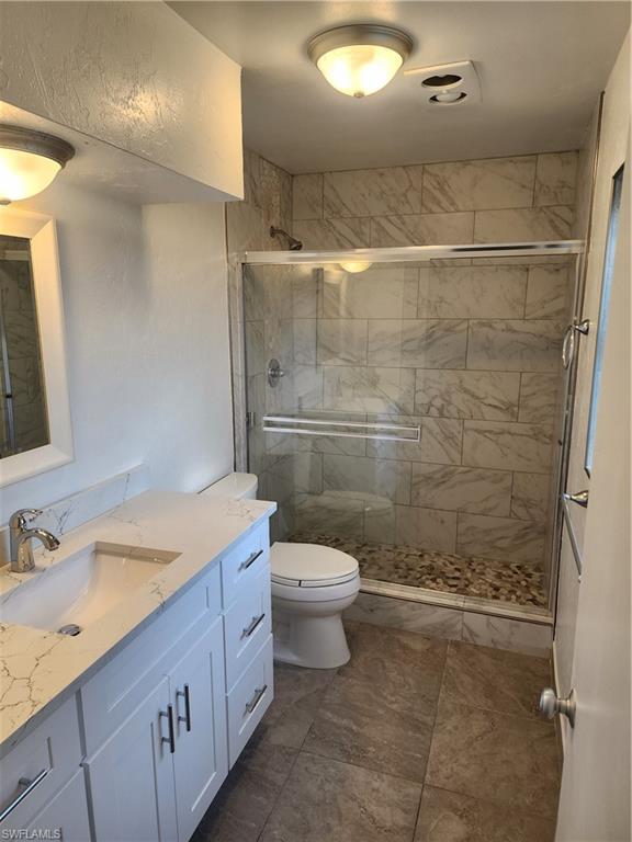 200 Willoughby Drive Naples, FL 34110 - Photo 7 of 15 Bathroom featuring vanity, toilet, and walk in shower