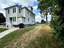 168 Wheatland Avenue, Unit 2 Chicopee, MA 01020 - Photo 15 of 15 a view of a white house with a big yard and large trees