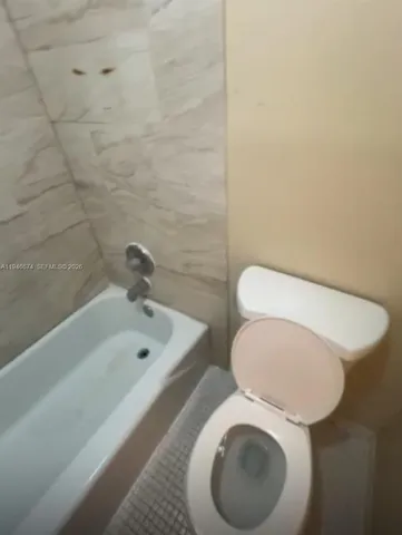 a bathroom with a toilet and a bathtub
