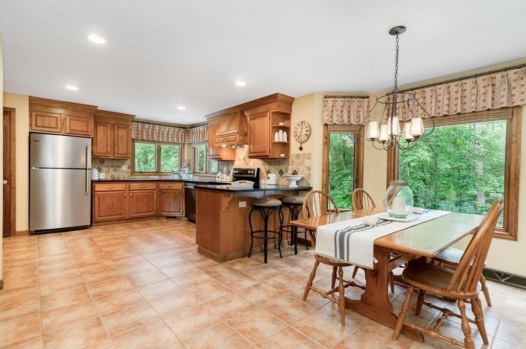 58 York Road Mansfield, MA 02048 - Photo 6 of 42 a kitchen with stainless steel appliances kitchen island granite countertop a refrigerator a stove a sink dishwasher with a dining table and chairs