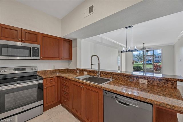 a kitchen with granite countertop a sink and stainless steel appliances