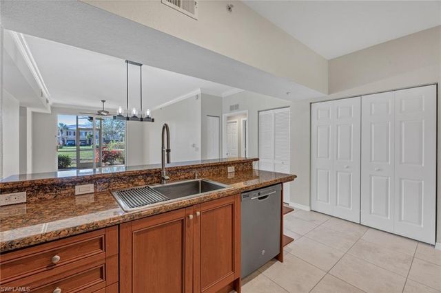 a kitchen with granite countertop a sink and white cabinets