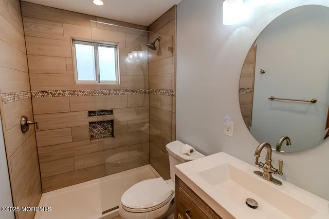 a bathroom with a sink a toilet and shower