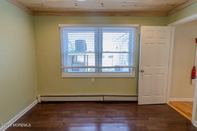 a view of a room with wooden floor and a window
