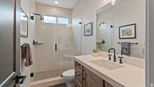 355 East Overlook Loop Hideout, UT 84036 - Photo 24 of 40 Main level 2nd bathroom featuring a spacious glass-enclosed shower with mosaic tile flooring, a custom wood-finish vanity with an integrated sink, matte black fixtures, and a transom window for natural light