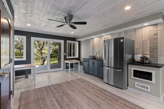 a kitchen with stainless steel appliances granite countertop a refrigerator oven a sink dishwasher and a stove with wooden floor