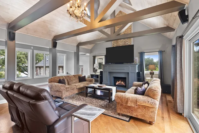 a living room with furniture a fireplace and a large window