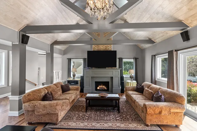 a living room with furniture a flat screen tv and a fireplace