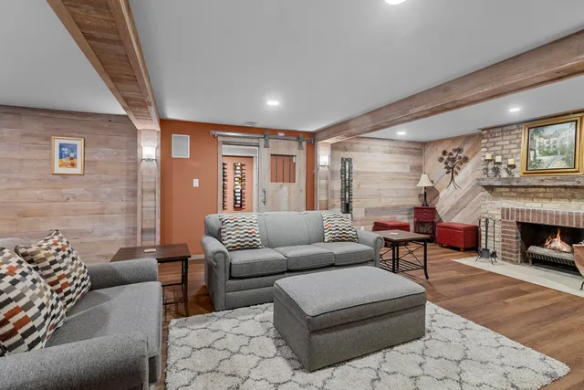 a kitchen with stainless steel appliances a stove a sink a refrigerator and chairs