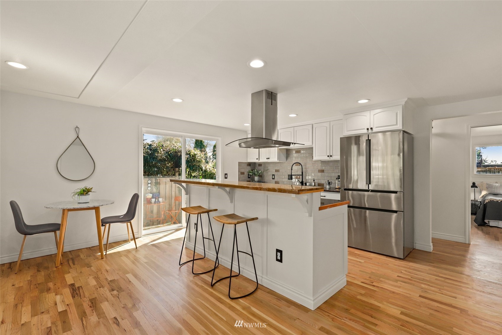 8817 37th Avenue Southwest Seattle, WA 98126 - Photo 9 of 40 a kitchen with stainless steel appliances granite countertop a refrigerator a stove and white cabinets with wooden floor