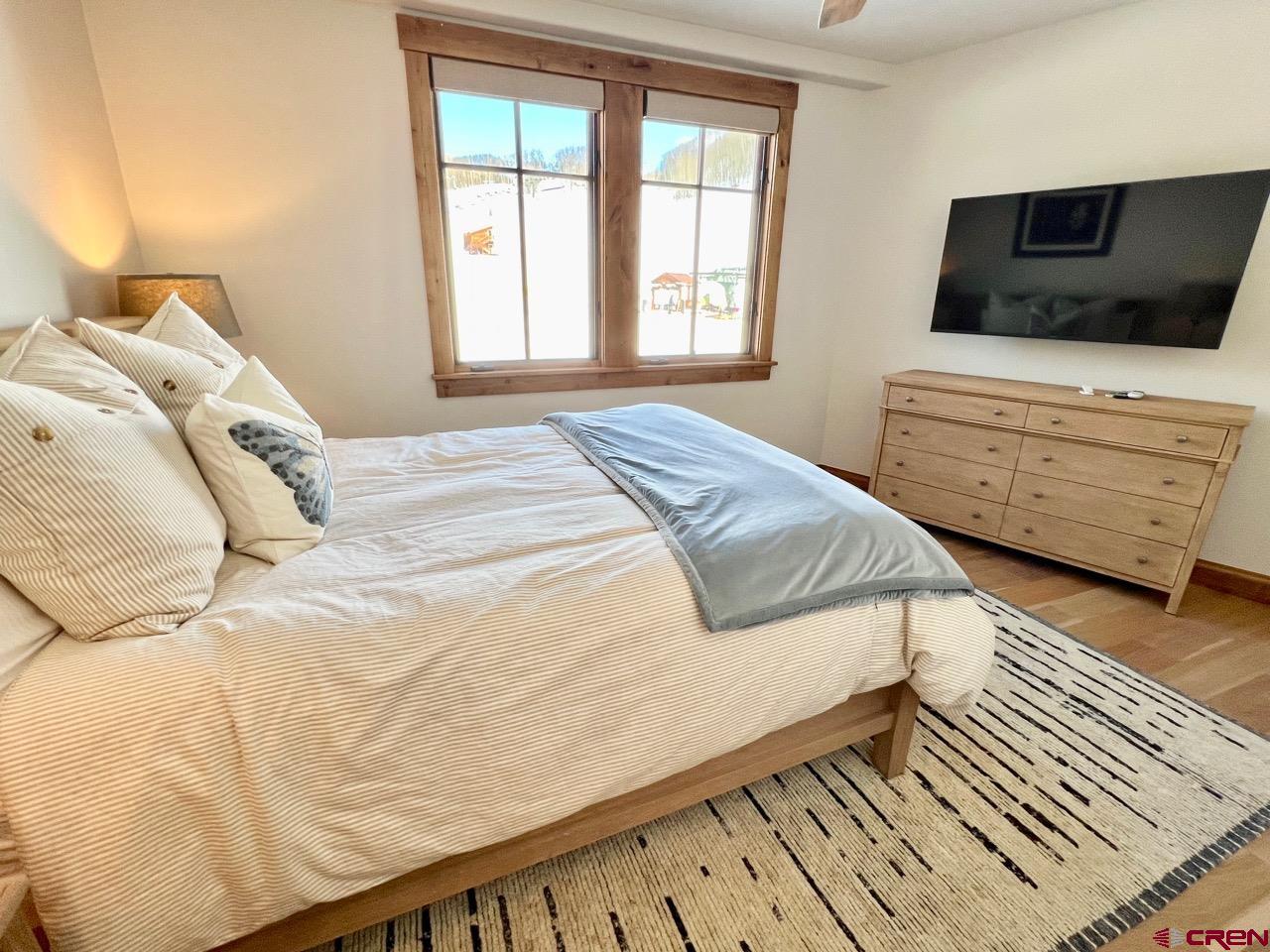 14 Hunter Hill Road, Unit C203 Crested Butte, CO 81225 - Photo 18 of 34 a bedroom with a bed and flat screen tv