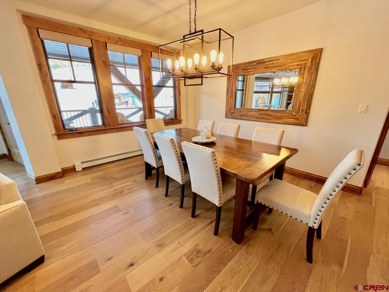 14 Hunter Hill Road, Unit C203 Crested Butte, CO 81225 - Photo 10 of 34 a dining room with wooden floor a chandelier a glass table and chairs