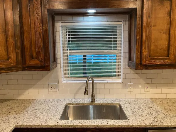 a bathroom with a granite countertop sink a toilet and mirror