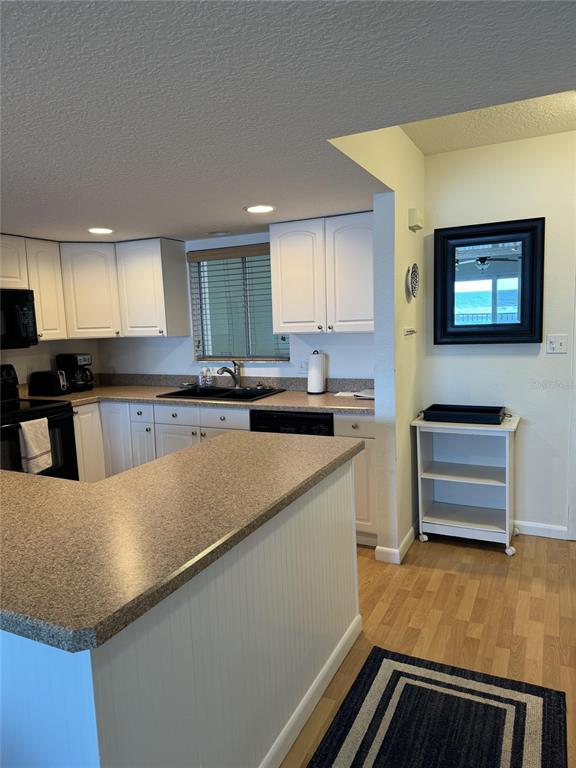 815 Ocean Shore Boulevard, Unit 13A Ormond Beach, FL 32176 - Photo 4 of 11 a kitchen with stainless steel appliances granite countertop a sink and a stove