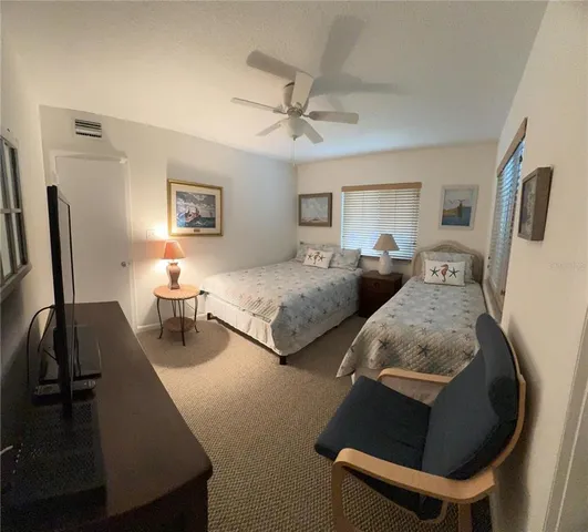 a bedroom with two beds and a flat screen tv
