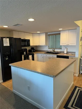 a kitchen with stainless steel appliances granite countertop a sink a stove top oven a counter space and cabinets