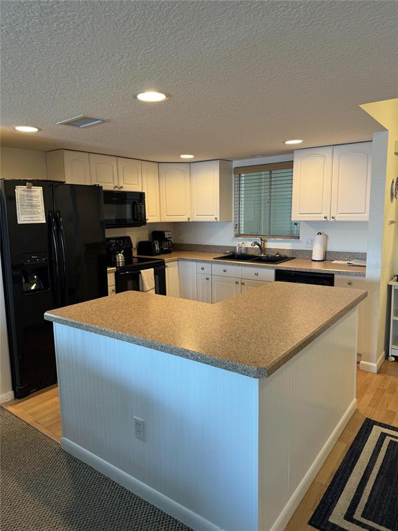 815 Ocean Shore Boulevard, Unit 13A Ormond Beach, FL 32176 - Photo 8 of 11 a kitchen with stainless steel appliances granite countertop a sink a stove top oven a counter space and cabinets