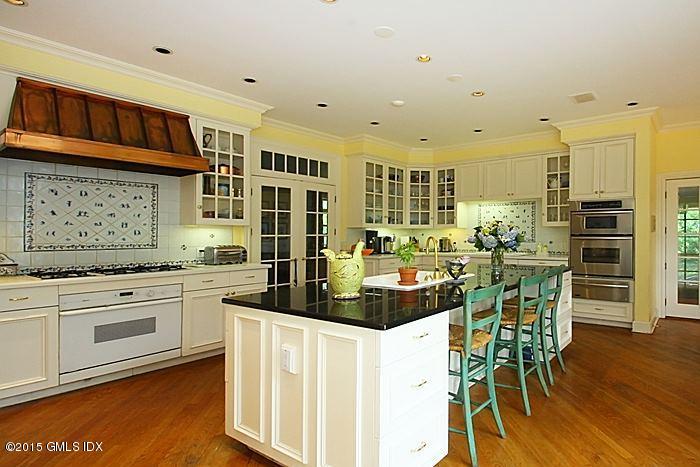 25 Ridgeway Greenwich, CT 06831 - Photo 14 of 25 a kitchen with stainless steel appliances kitchen island granite countertop a stove a refrigerator and white cabinets with wooden floor