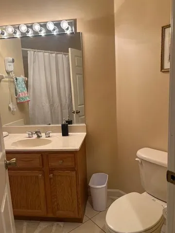 a bathroom with a granite countertop toilet sink and mirror