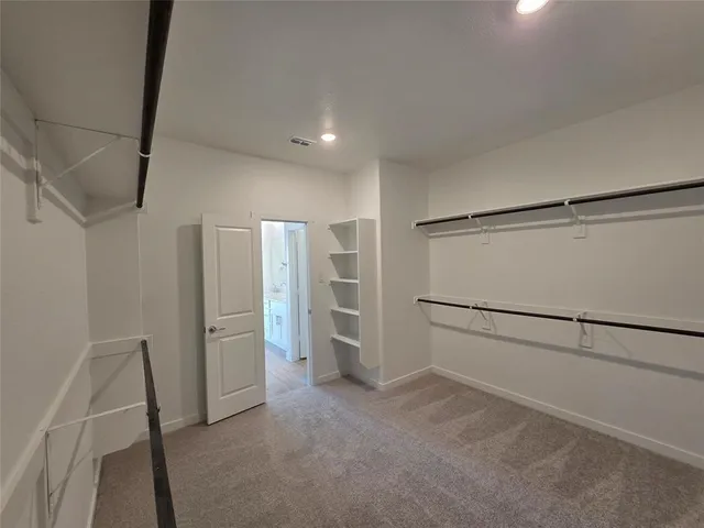 a view of walk in closet with empty racks