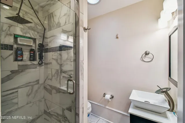 a bathroom with a sink a toilet and shower