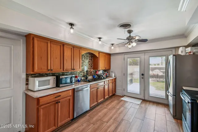 a kitchen with a refrigerator a stove top oven a sink and cabinets