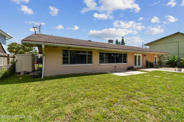 an aerial view of a house with a garden and lake view