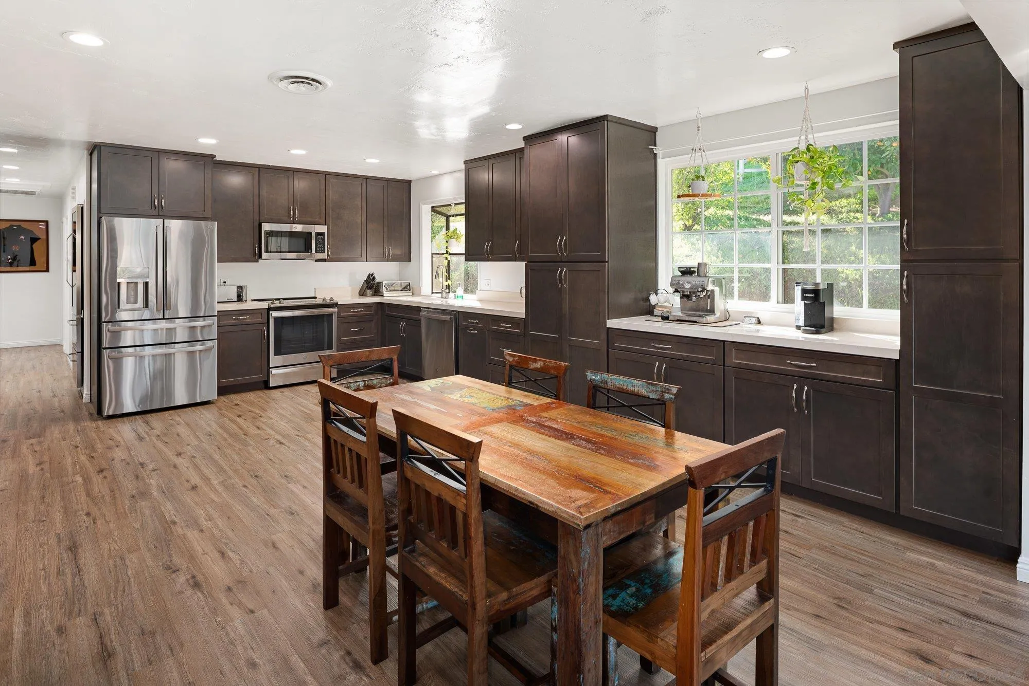 1780 Grove Road El Cajon, CA 92020 - Photo 15 of 59 a kitchen with stainless steel appliances a table chairs refrigerator and wooden floor