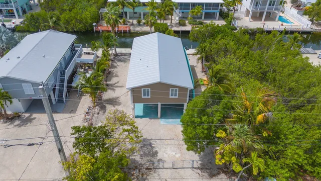 an aerial view of a house with garden space and a bench