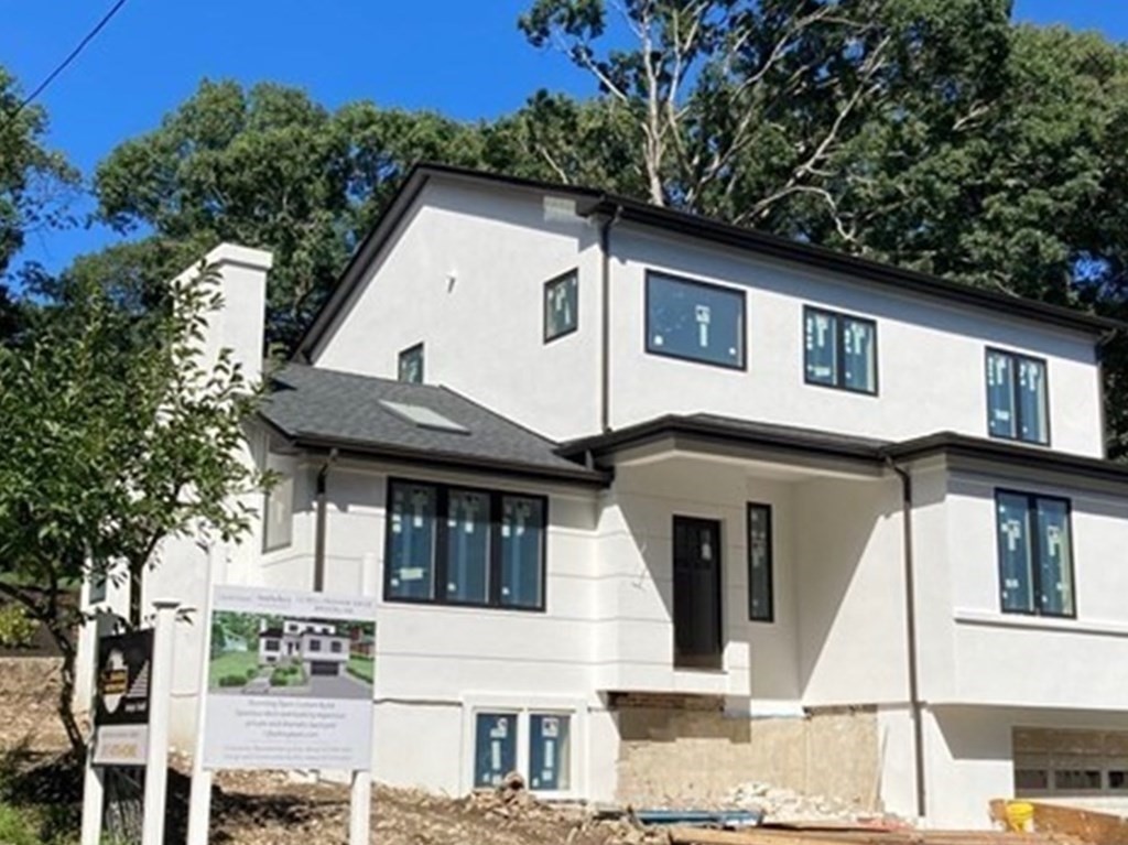 12 Bellingham Drive Brookline, MA 02467 - Photo 2 of 4 a view of a white house with large windows and a tree
