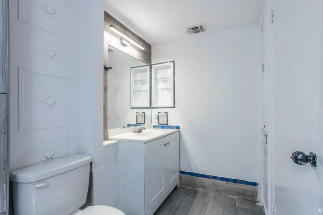 a bathroom with a toilet sink and mirror