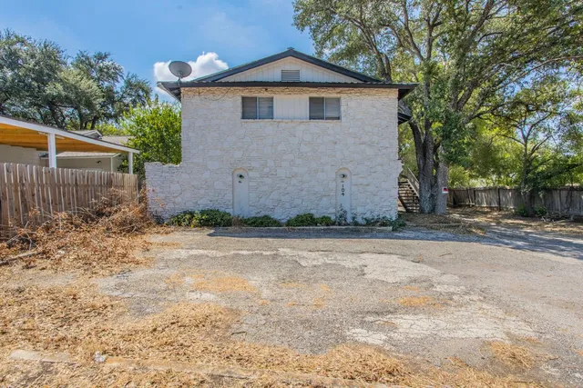 a view of a yard in front of a house with large tree
