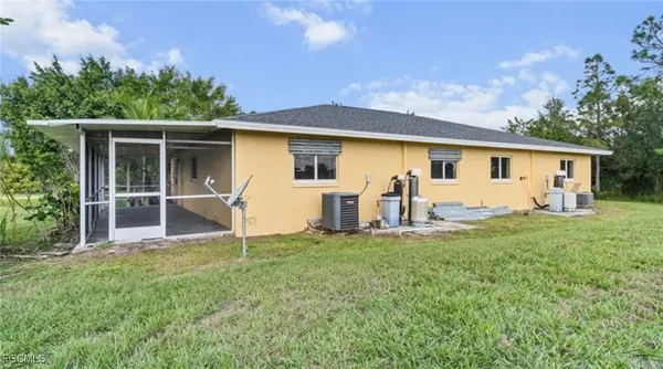 a view of a house with backyard and a tree