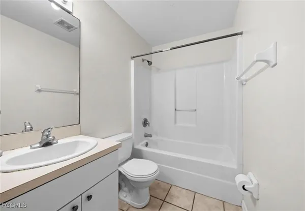 a bathroom with a granite countertop sink a toilet and shower