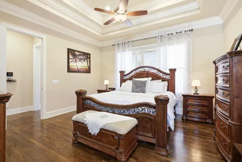 a bedroom with a bed window and wooden floor
