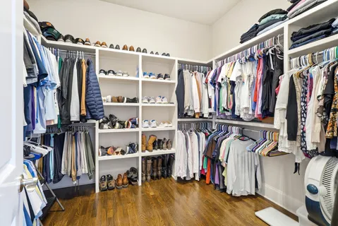 a view of walk in closet with clothes and shoes