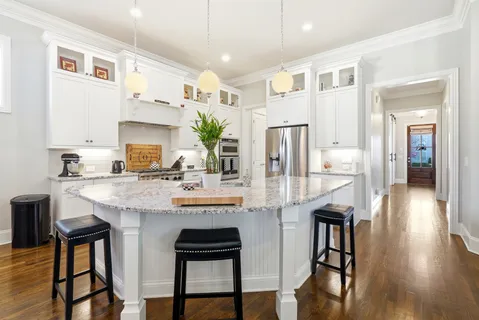 a kitchen with kitchen island granite countertop a sink and cabinets