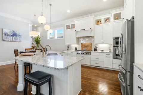 a kitchen with stainless steel appliances granite countertop a sink stove and refrigerator