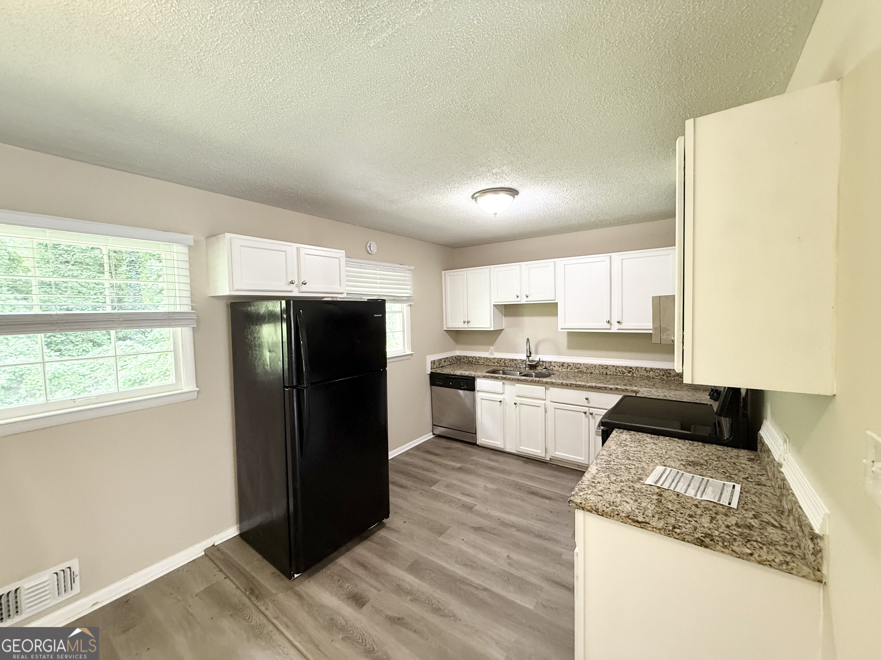 2782 Ocean Valley Road Atlanta, GA 30349 - Photo 9 of 27 a kitchen with a refrigerator and a stove top oven