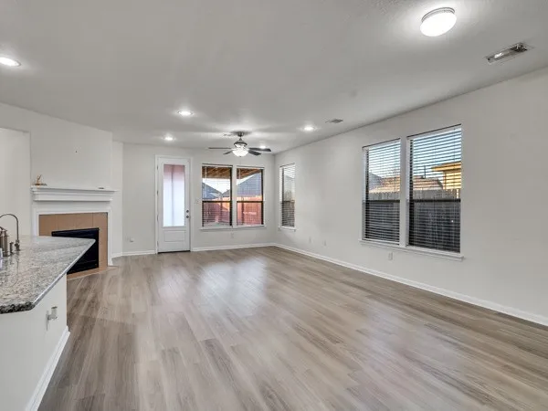 an empty room with windows and fireplace