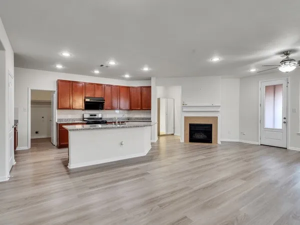 a view of kitchen with microwave oven a refrigerator and cabinets