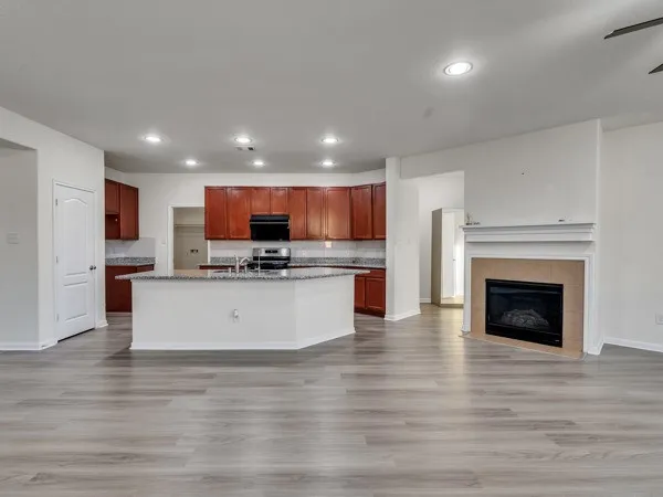 a view of kitchen with kitchen island granite countertop stainless steel appliances refrigerator and cabinets