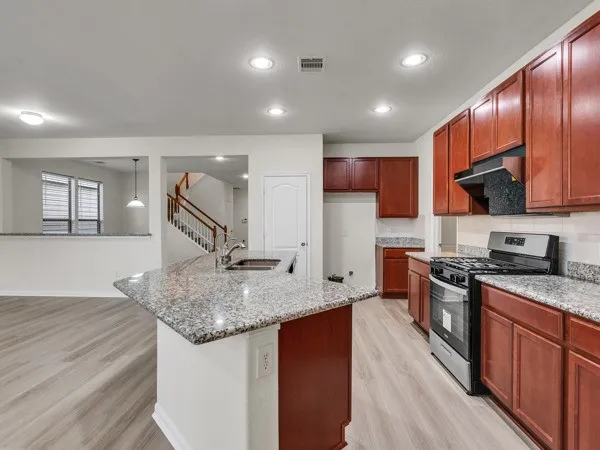a kitchen with stainless steel appliances granite countertop wooden cabinets a sink and dishwasher