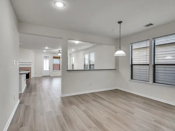 a view of empty room with wooden floor and window