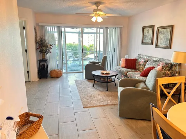 a living room with furniture a lamp and a floor to ceiling window