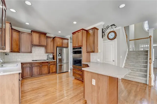 a large kitchen with stainless steel appliances granite countertop a stove and a refrigerator