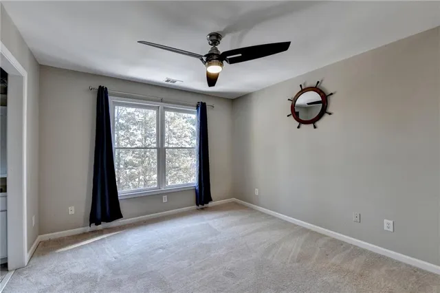 an empty room with windows and fan