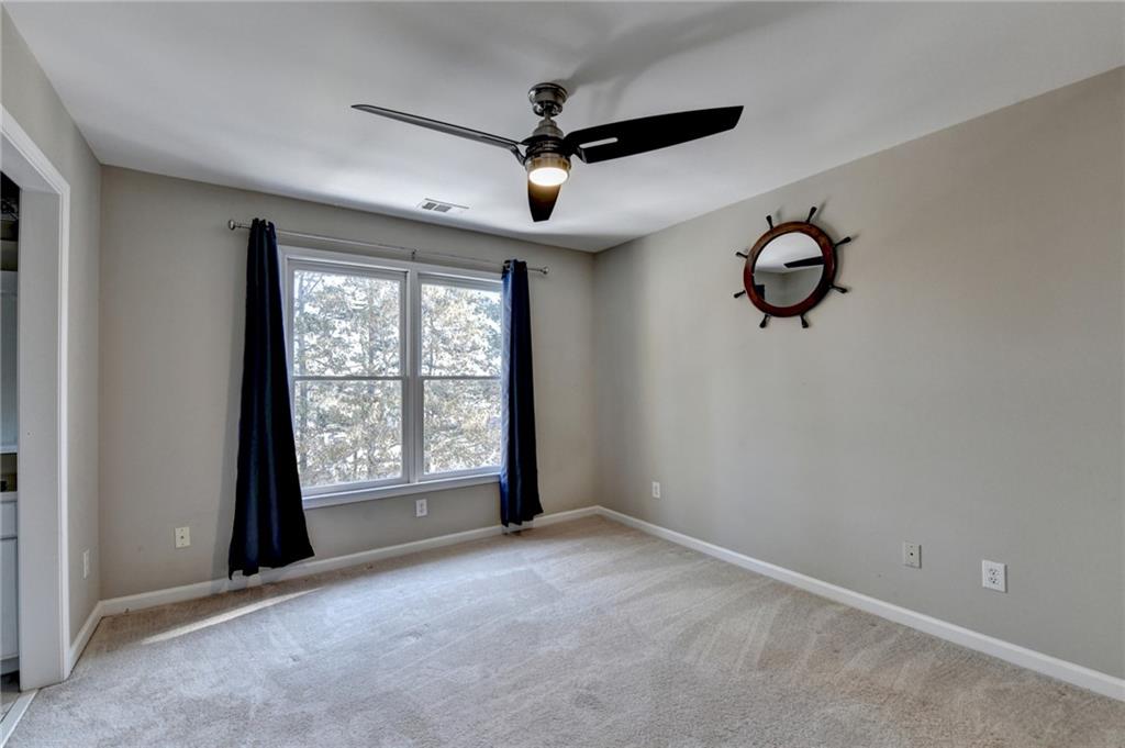 1601 Woodbow Crossing Dacula, GA 30019 - Photo 19 of 51 an empty room with windows and fan